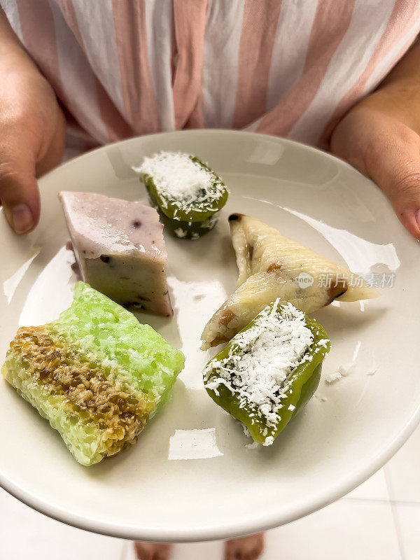 多种族妇女提供传统素食Nyonya Kuih Pandan，椰子，蛋糕